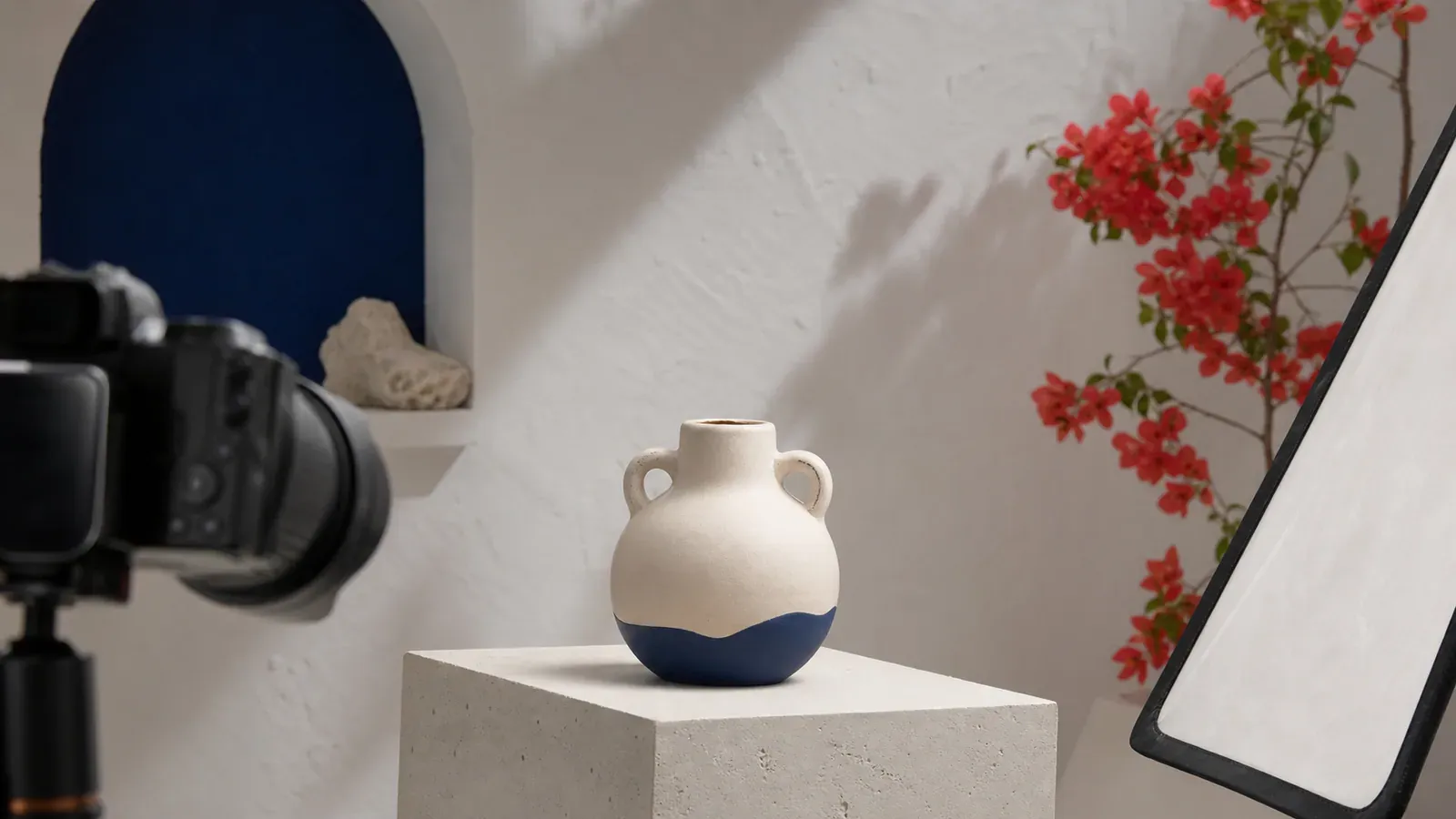 Camera, reflector, and ceramic product arranged in a Mediterranean photo studio